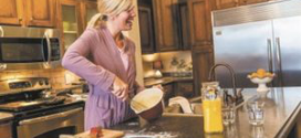 woman-cooking-kitchen-claytonhomes-therevew=credit-posted-manufacturedhomelivingnews-com-